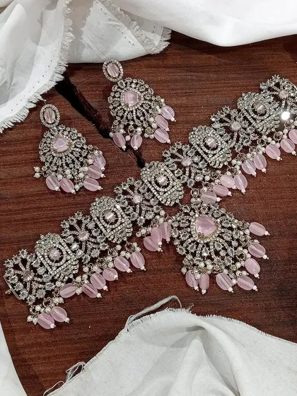 This lovely Victorian choker set in pastel pink is perfect for a romantic and feminine look. The soft pink beads and stones are set in detailed silver-tone metalwork, complete with matching earrings.