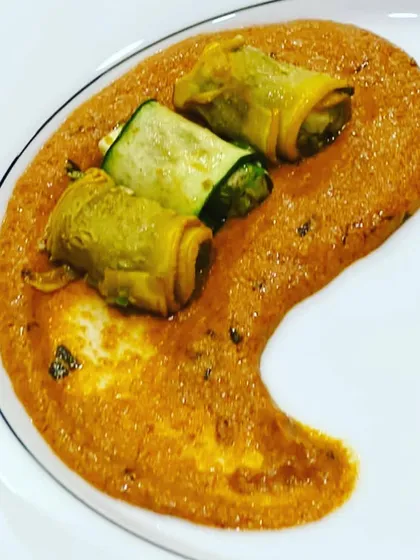 Zucchini roulade served on a bed of rich makhani gravy, a perfect example of our innovative approach to vegetarian main courses.