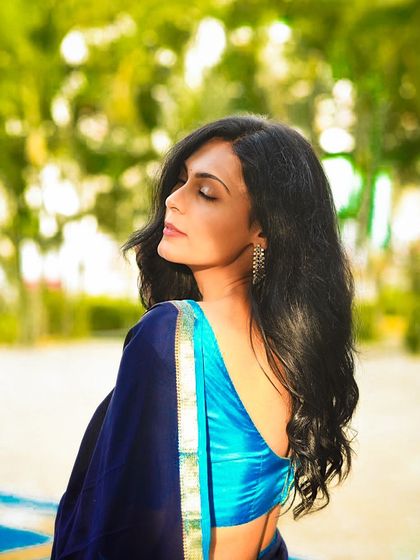 An elegant profile shot taken outdoors, highlighting the subject's features and the beautiful flow of her hair.