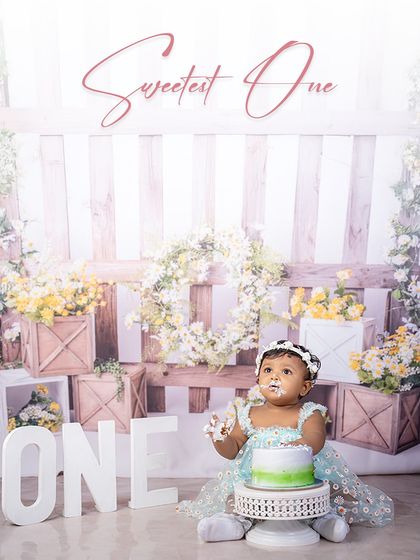 The sweetest one has arrived! This little girl, with frosting on her face, is the picture of birthday delight in a rustic and floral garden-themed cake smash.