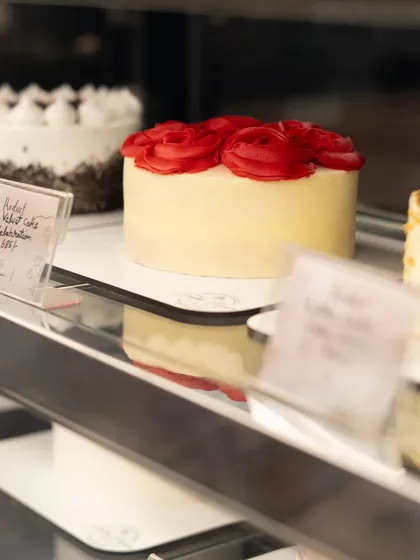 A shot of the cake display at a bakery. This type of photo helps customers see the variety of products available and captures the real-life cafe experience.