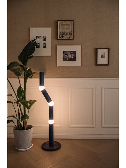 The den in Kanso House is a multi-functional space that serves as a sitting room, guest room, or prayer room. The walls are sheathed in jute wallpaper and adorned with the clients' personal black and white photographs, creating a gallery of memories.