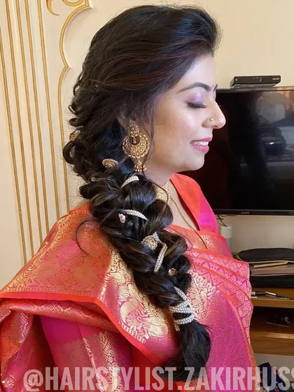 A beautiful side-swept bubble braid adorned with pearl-and-gold accessories. This is a glamorous and modern take on a traditional braid.