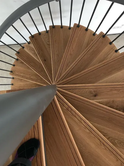 A detailed look from above at the solid oak treads on a spiral staircase. Each step includes a custom walnut inlay, a small detail that adds a lot of character.