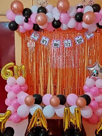 A clear shot of the half-birthday party decoration. All elements, from the balloon colors to the foil letters, are coordinated to create a festive photo corner.