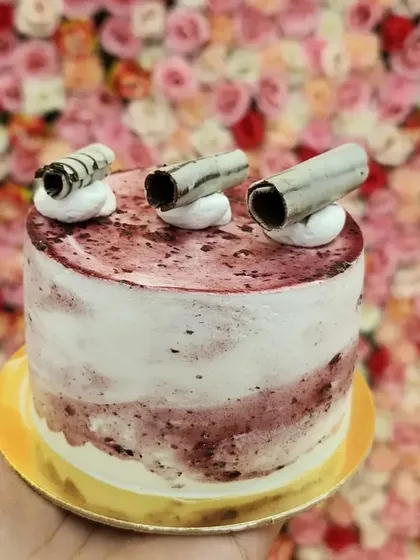 A mini cake with a fruity twist. This is my mini blueberry cake, with a beautiful marbled frosting and delicate chocolate curls on top. It's a light and refreshing option for a small, sweet treat.