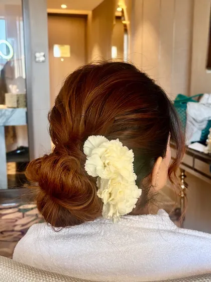 A candid shot of the textured bun being styled. Even in a bathrobe, you can see how elegant and beautiful this romantic updo looks.