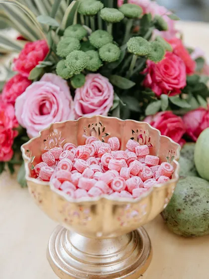A sweet detail. A brass bowl filled with traditional Indian candies, adding a touch of nostalgia and color.