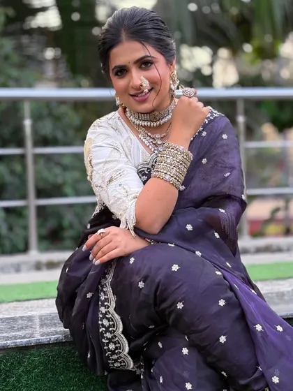 A candid moment capturing the bride's happy and relaxed expression. The natural lighting highlights the smooth skin finish and the subtle shimmer on her eyes, perfect for daytime wedding events.