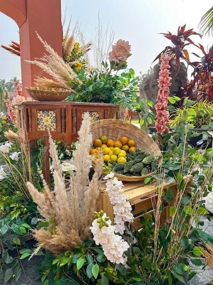 Fresh produce like bitter gourds and lemons are artfully arranged with pampas grass and florals, adding a touch of rustic realism to the 'Souk Bazaar' theme.