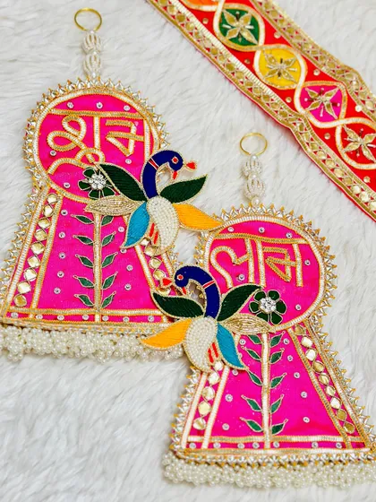 A beautiful pink latkan set with peacock motifs and gota patti work. This design is elegant and perfect for adding a graceful touch to your home.