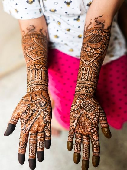 This design features beautiful peacocks on the forearms, a symbol of grace and beauty in bridal henna.