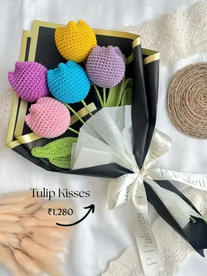 The 'Tulip Kisses' bouquet is a vibrant mix of six colorful tulips, expertly wrapped in black paper to make the colors pop. A perfect gift for Mother's Day or any day.