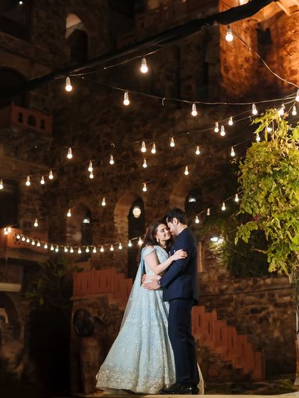 A repeat of image 241, a romantic portrait of a couple dancing under string lights at their sangeet.