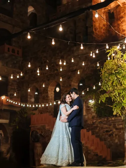 A repeat of image 241, a romantic portrait of a couple dancing under string lights at their sangeet.
