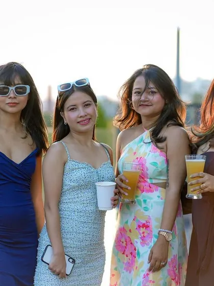 Guests enjoying the sun and drinks at the pool party.