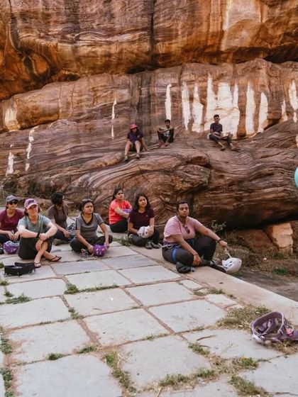 A helmet is non-negotiable for outdoor climbing. Here, an instructor explains the importance of safety gear to a group of new climbers at our Badami event.
