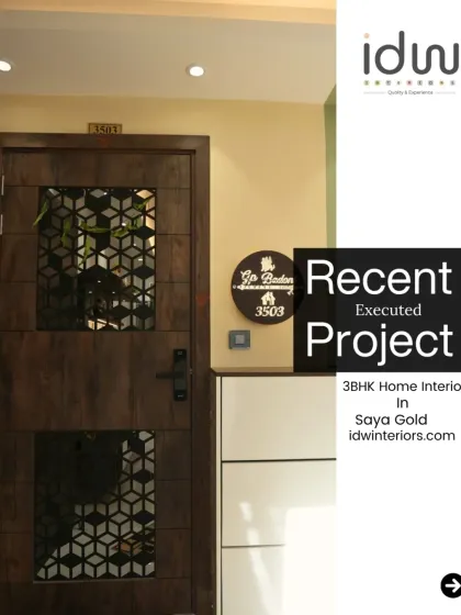A sophisticated entrance at Saya Gold. The dark wood door with a geometric grill is paired with a simple shoe cabinet and a personalized nameplate.