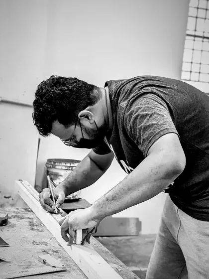 Focus and precision. A maker carefully marks his measurements before making a cut. This attention to detail is what hand tool woodworking is all about.
