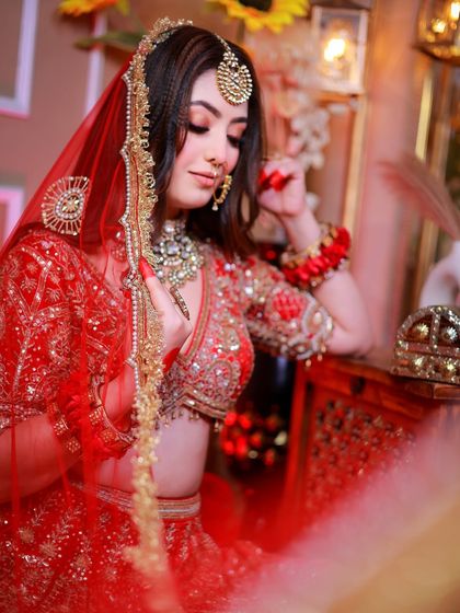 A soft and romantic portrait with the bride looking through her red veil.
