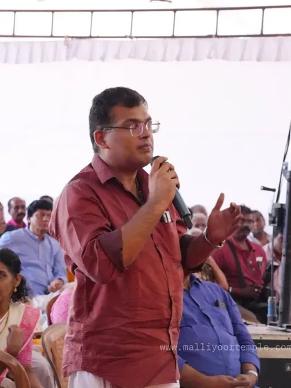 A member of the audience asking a question during the event at Malliyoor Temple. Public engagement is a key part of these gatherings.