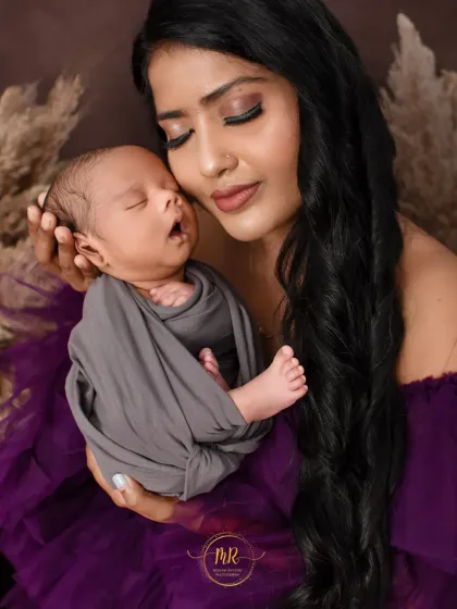 A mother cradles her sleeping newborn, her eyes closed, savoring the quiet moment.