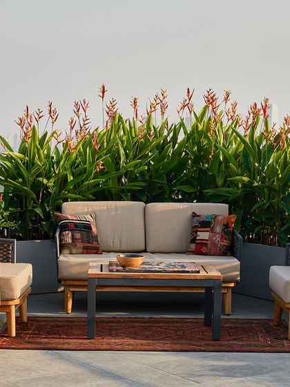 This cozy seating arrangement on the terrace is perfect for enjoying the open air, surrounded by planters that add a touch of nature to the rooftop setting.