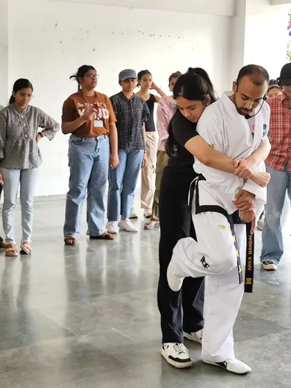 A key part of our training is learning to escape common holds. This image shows a student at our LSR College workshop practicing a technique to break free from a rear grab, a crucial skill for personal safety.