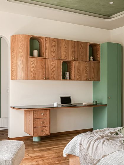 A different view of the study area, showing how the green accent color is carried through to the full-height storage unit and the painted ceiling inset.