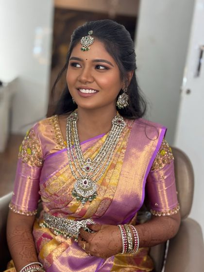 A side profile of Gopika during her reception. The lighting catches the beautiful contour and highlight on her cheeks, adding dimension to her glowing makeup look.