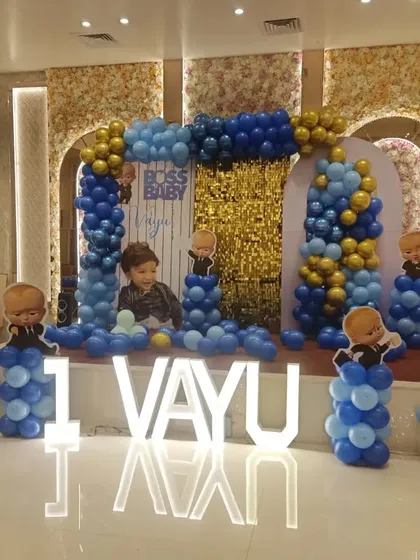 The full view of the Boss Baby themed stage for Vayu's first birthday party in Noida. The large, illuminated letters really make the birthday boy's name stand out.