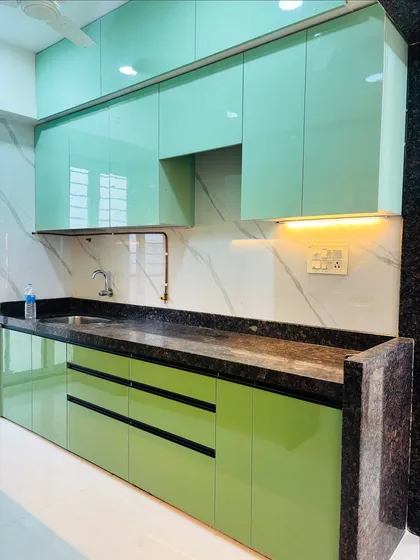 Another perspective of the mint green modular kitchen, showing the clean lines and flawless high-gloss finish on the cabinetry.