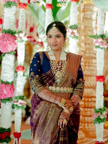 A full shot of the client at her event, looking poised and graceful against the decorated pillars.
