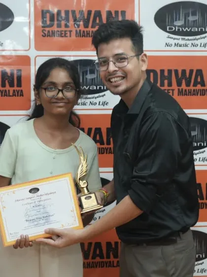 A teacher presents an award to a student.