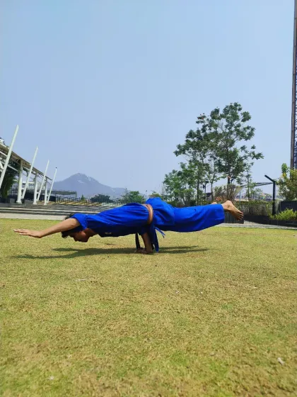 The full expression of the Mayurasana pose, performed outdoors. This demonstrates the ability to hold the body parallel to the ground, a feat of strength that is a goal for many of our advanced students.