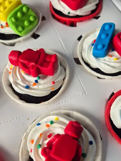 A close-up of the LEGO man cupcakes. These fun, edible toppers are perfect for a LEGO-themed birthday party and are part of a set with a matching cake.