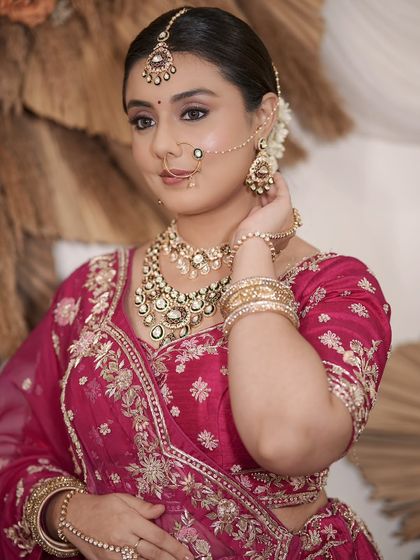 A complete bridal look featuring a heavy, gold-plated Kundan necklace, haath phool, and maang tikka, all available for rent.