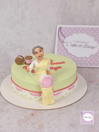This cake for an 84th birthday celebrates a love for sewing. It features a figurine of the birthday woman with her sewing basket, and I finally got to try a vintage ribbon lace effect on the side.