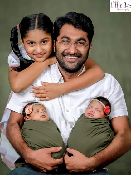 A happy family portrait with a father, his older daughter, and his newborn twins. It's a joy to capture the love in a growing family.