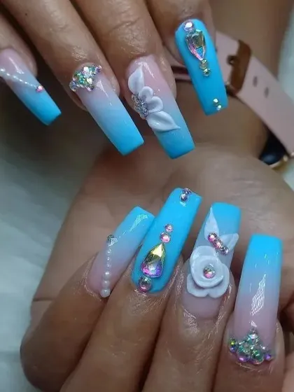 Indulge in ultimate glamour with these extra-long coffin nail extensions. This set showcases a soft blue ombré, intricate 3D floral sculptures, and a lavish arrangement of multi-sized rhinestones and pearl accents for a truly show-stopping effect.