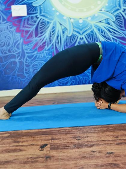 A student holds a deep forearm wheel pose (Dvi Pada Viparita Dandasana), a powerful chest and shoulder opener.