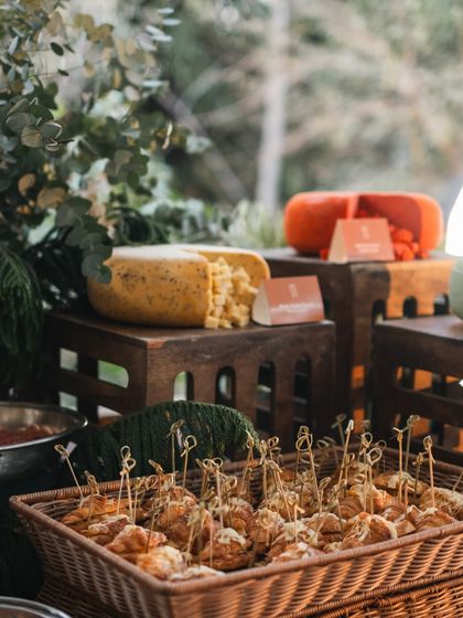 A closer look at the cheese and pastry section of our high tea grazing table. The textures of the wicker basket and wooden crates complement the natural setting.
