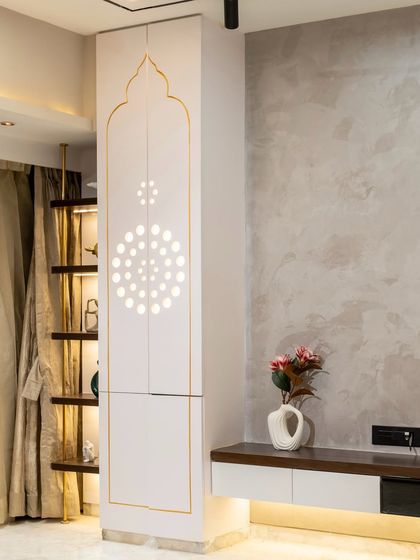 A sacred space where design meets devotion. This bespoke living room mandir features PU shutters with thoughtfully crafted circle cutouts, allowing the space to breathe naturally while maintaining a serene, minimalistic elegance.