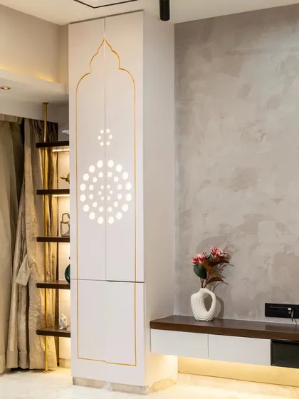 A sacred space where design meets devotion. This bespoke living room mandir features PU shutters with thoughtfully crafted circle cutouts, allowing the space to breathe naturally while maintaining a serene, minimalistic elegance.