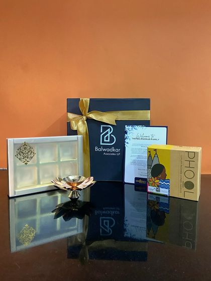 A thoughtful corporate order for Balwadkar Associates LLP. This hamper includes a sweet box, Phool incense, and a lotus diya, all presented in a beautifully branded box.
