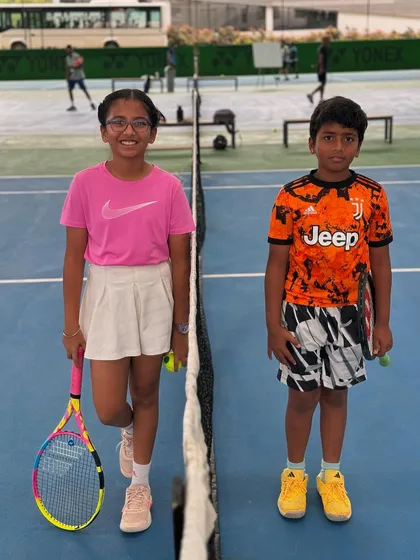 Two junior players ready for their match, showcasing the confidence and readiness we instill. We equip our kids with the right gear and mindset for the game.