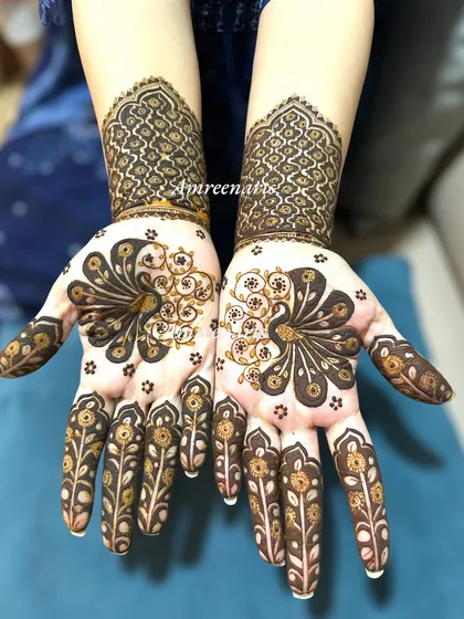 A gorgeous peacock design on the palm, with feathers that fan out beautifully. The cuff uses a traditional jaali pattern.