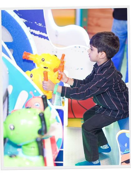 A young guest fully engaged in one of our arcade water shooter games. We have a wide variety of games to entertain children with different interests.