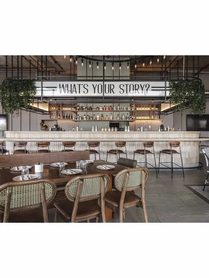 The bar's tagline, 'What's your story?', is the focal point of the project. It takes center stage, reinforcing the brand's identity and inviting guests to connect and share.