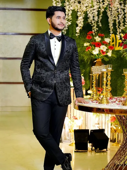 A stylish portrait of the groom leaning against a table at his engagement party. He looks confident and ready to celebrate.